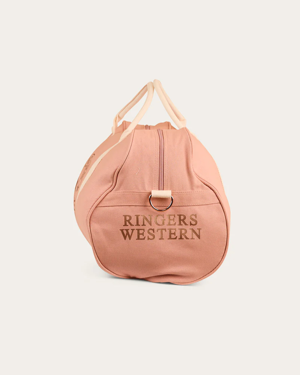 Pink duffel bag with 'Ringers Western' branding on a light beige background