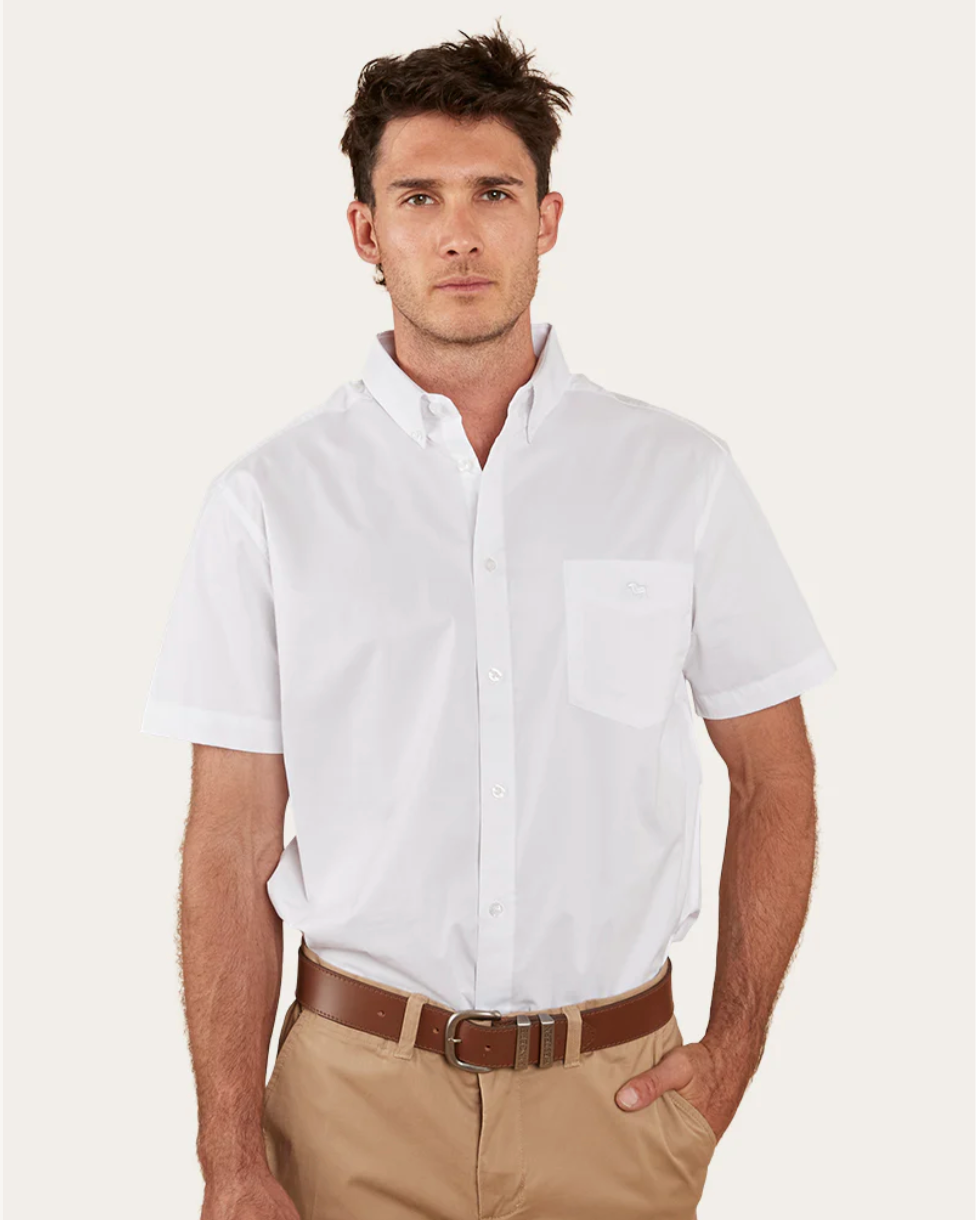 Man wearing a white short-sleeve shirt and beige pants on a light background