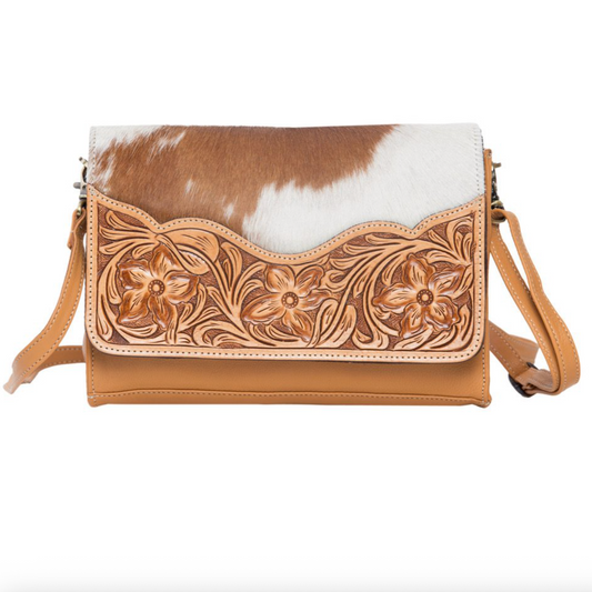 Handbag with floral tooled leather design and cowhide pattern on a white background
