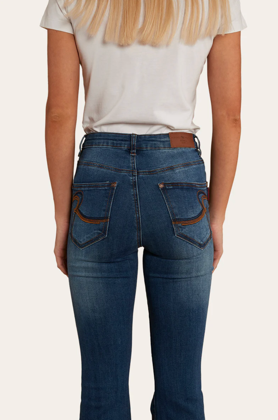 Blue Ringers Western flare leg jeans and a white tank top.