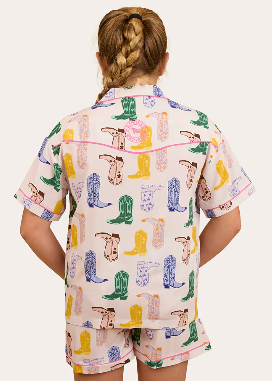 Person wearing a shirt with colorful cowboy boot pattern on a white background