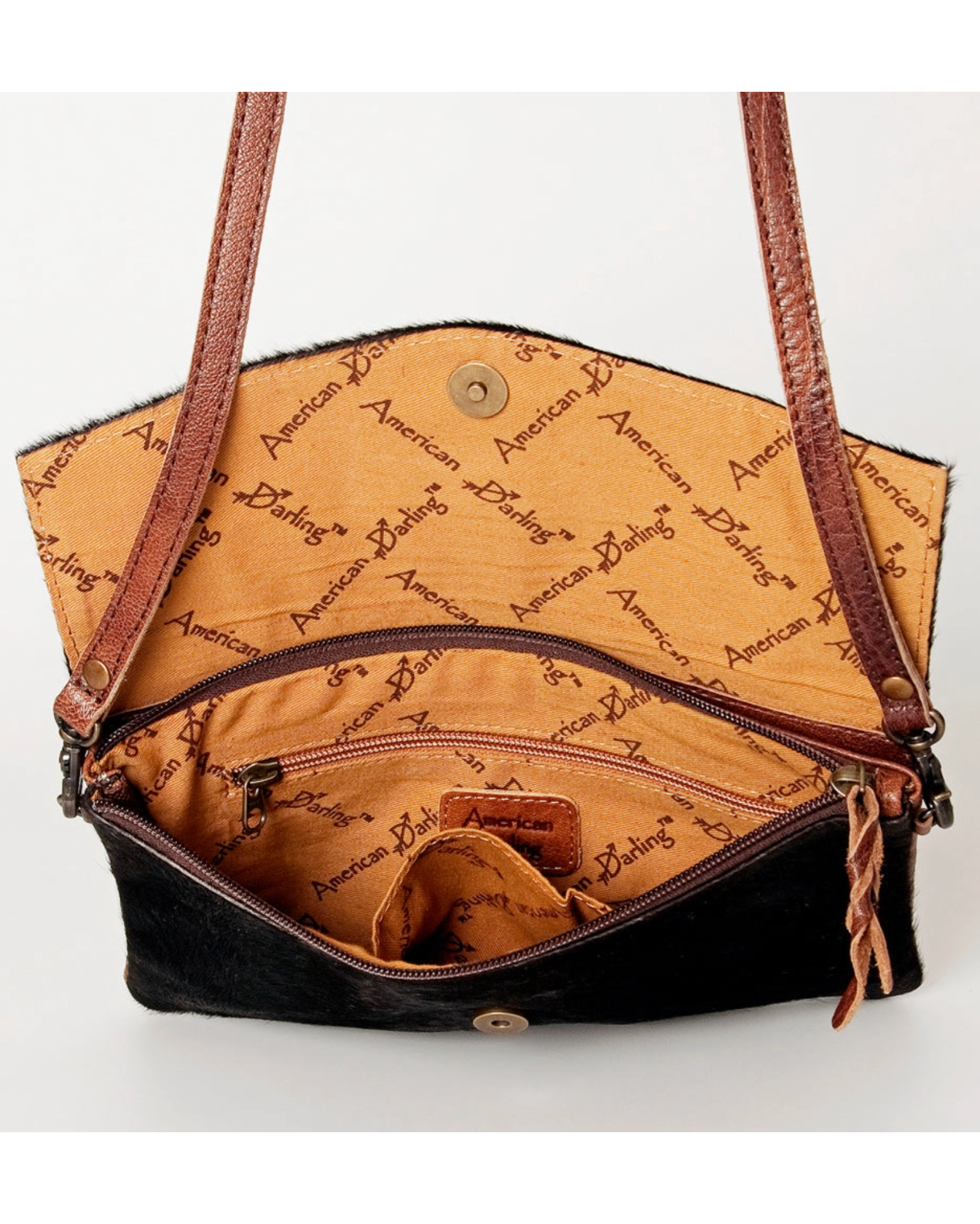 Brown leather handbag with 'American Darling' text on a white background