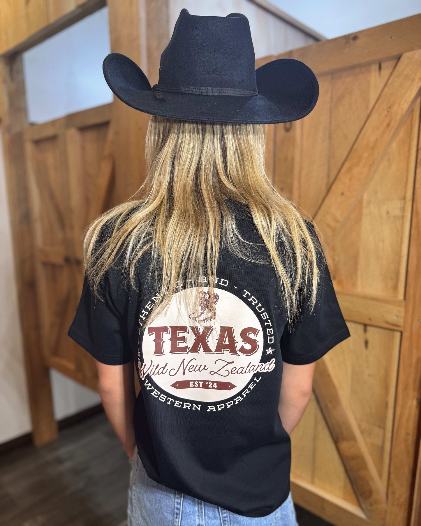 A black coloured Woman's Texas Western Apparel T-shirt with an embroidered "T" and cowboy boot on the front. The back features "Texas Western Apparel logo.