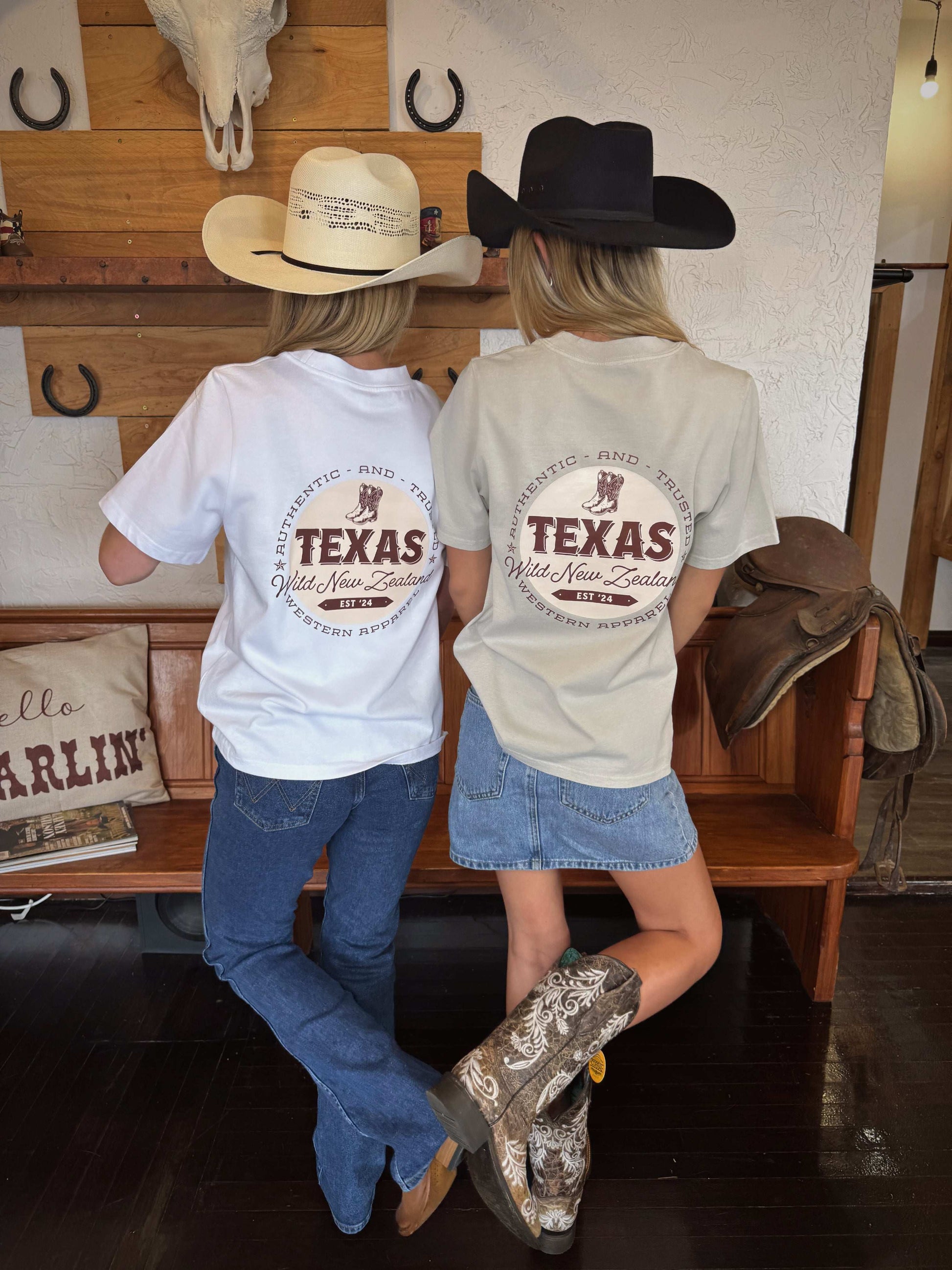 White t-shirt featuring the Texas Western Apparel logo on the front, with a distinctive design that includes bold lettering and western-inspired elements in a stylish, modern font