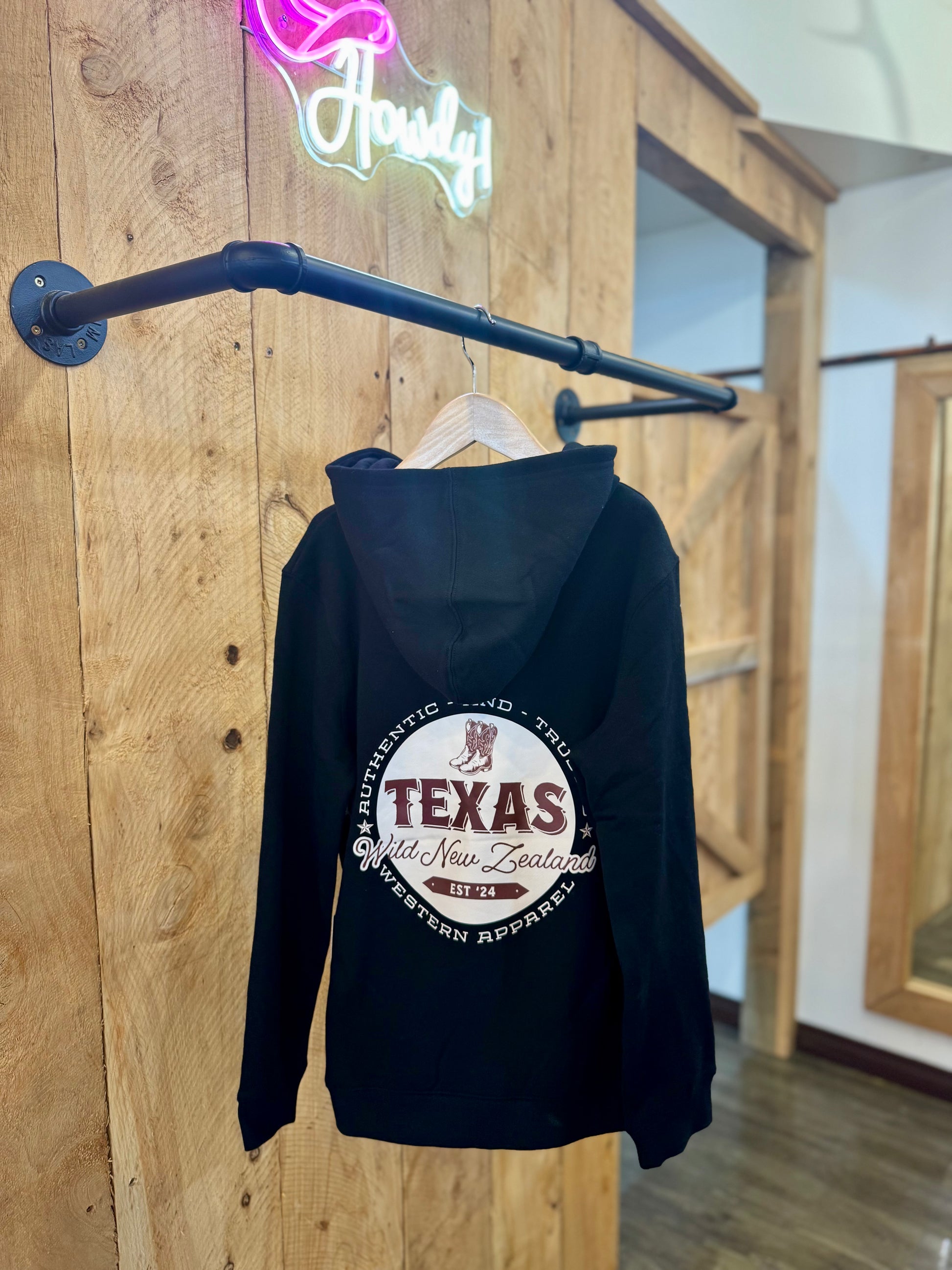 Black Texas Western Apparel youth/kids hoodie with detailed embroidery. The front features a stitched 'T' and a Western-style boot, while the back displays the Texas Western Apparel logo. Perfect for little cowboys and cowgirls who love bold Western style!