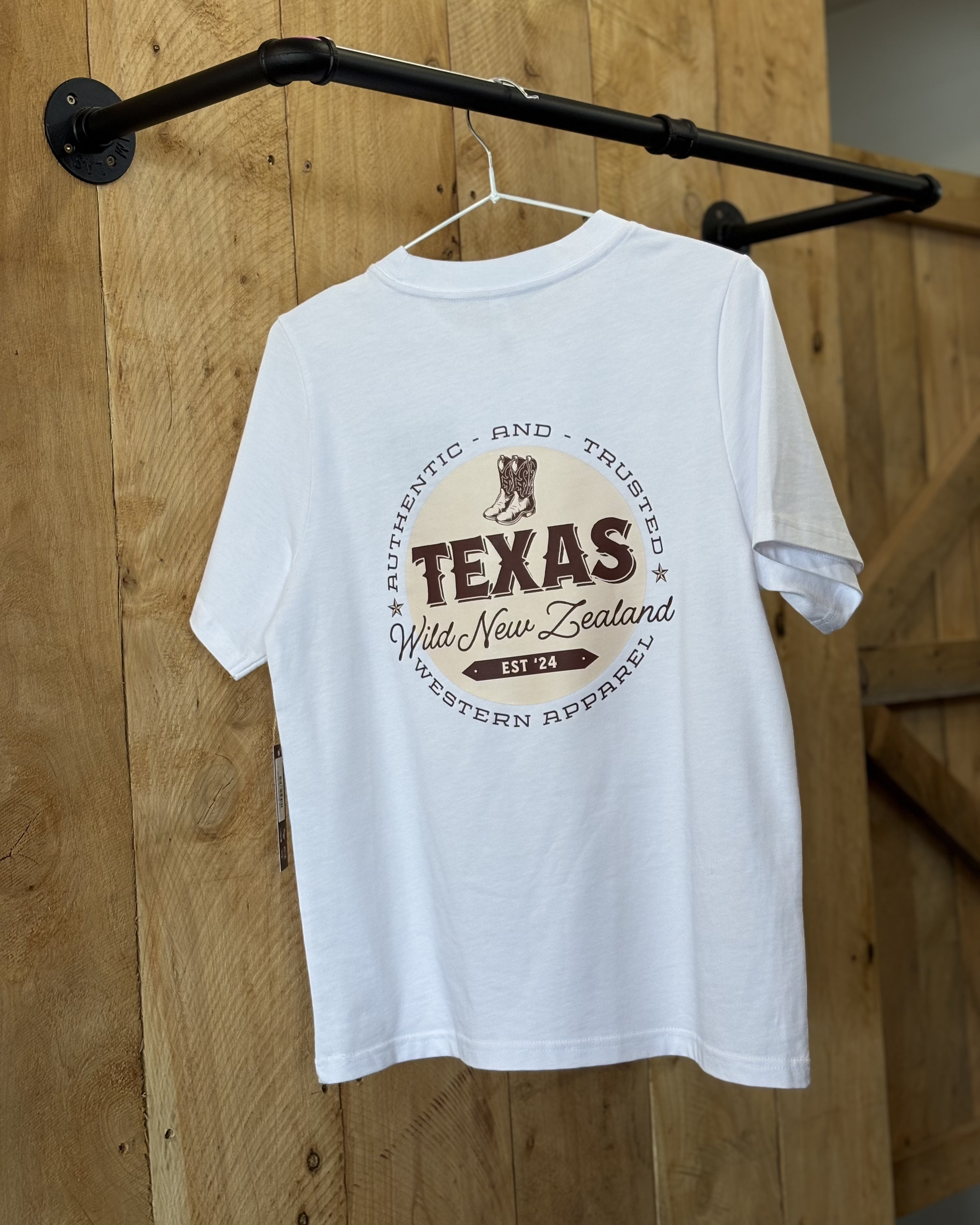 White t-shirt featuring the Texas Western Apparel logo on the front, with a distinctive design that includes bold lettering and western-inspired elements in a stylish, modern font