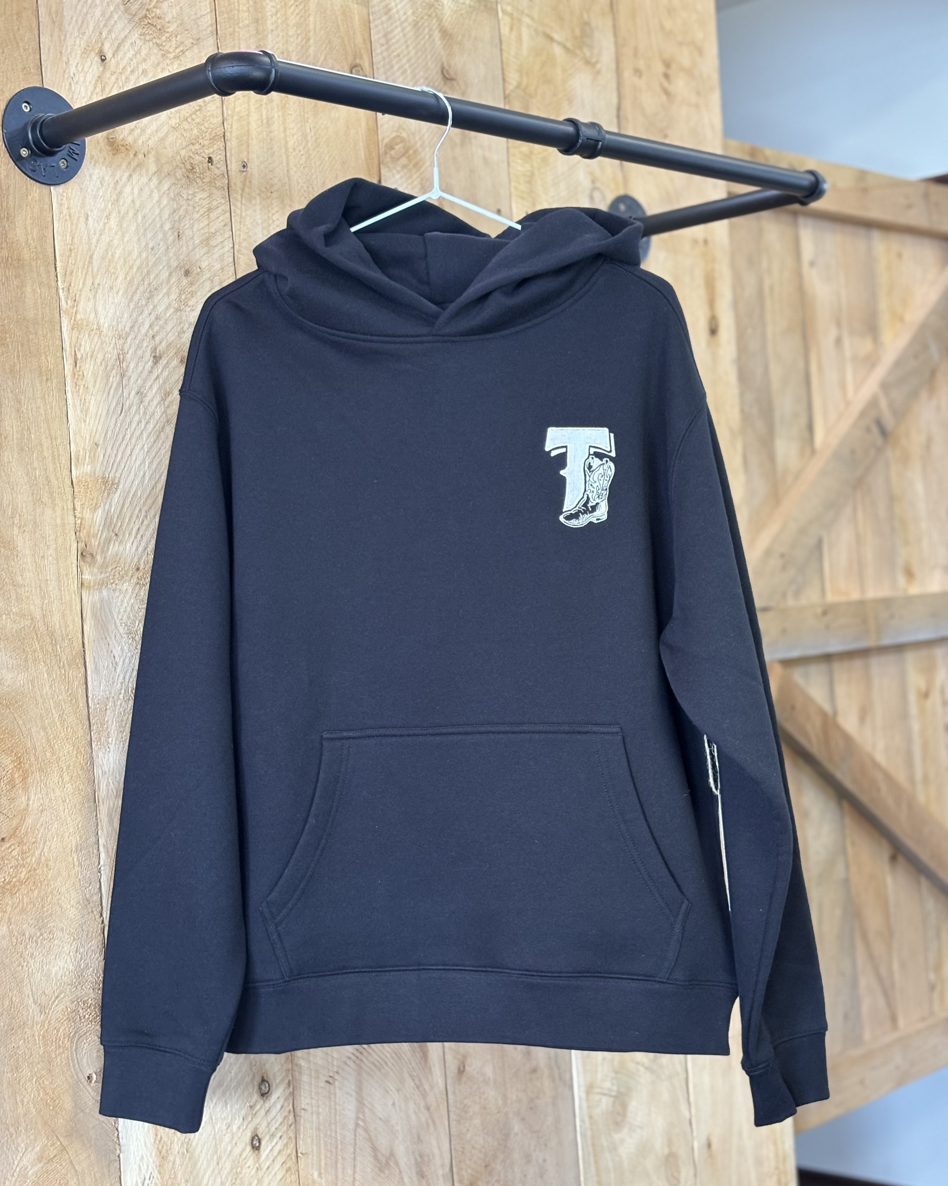 Black Texas Western Apparel hoodie with intricate embroidery. The front features a detailed embroidered 'T' and a Western-style boot, while the back showcases the Texas Western Apparel logo. A bold and stylish statement piece with a classic country flair.