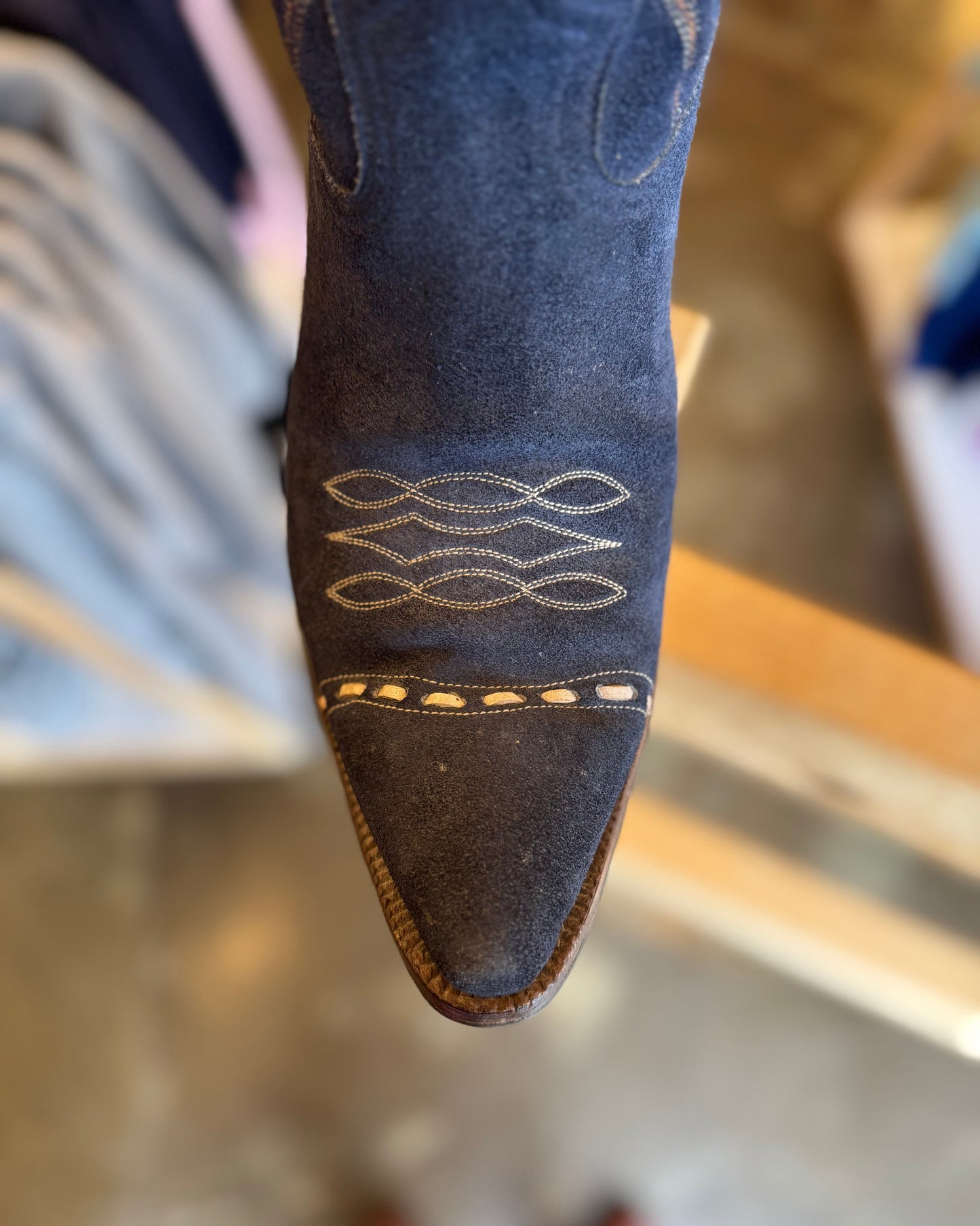 Close-up of a blue boot with decorative stitching on a blurred background