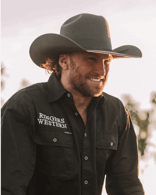 A classic charcoal cowboy hat by Ringers Western, made of premium wool felt with a structured crown and a wide, upturned brim. A matching charcoal hatband adds a refined touch.