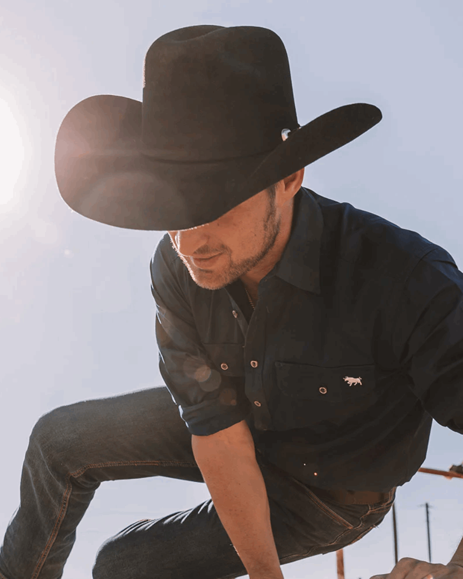 A classic black cowboy hat by Ringers Western, made of premium felt with a structured crown and a wide, upturned brim. A silver buckle accent on the hatband adds a refined touch.