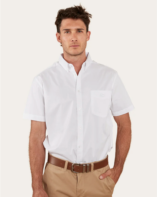 Man wearing a white short-sleeve shirt and beige pants on a light background