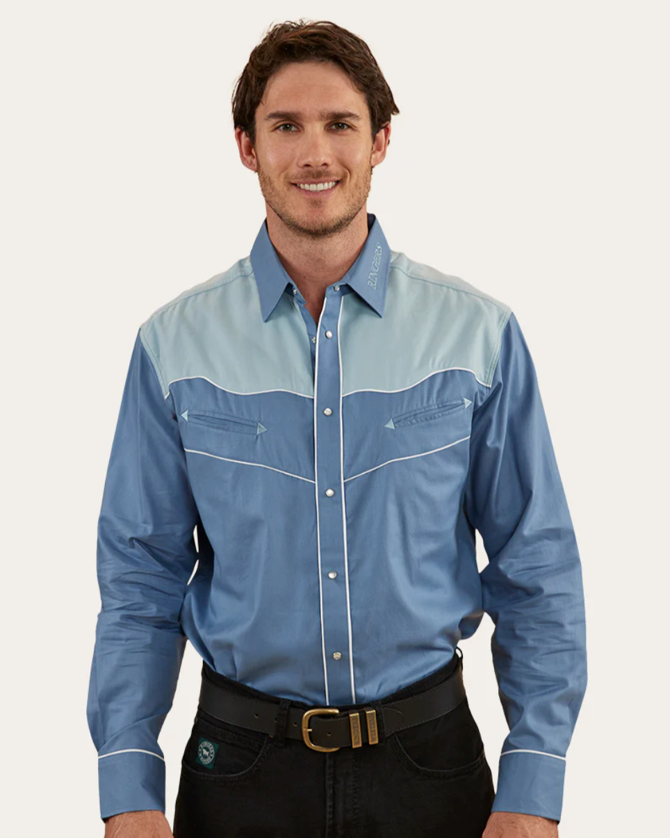 Man wearing a blue and gray checkered shirt with black pants on a white background