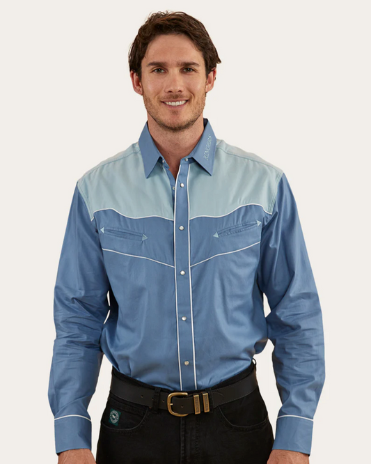 Man wearing a blue and gray checkered shirt with black pants on a white background