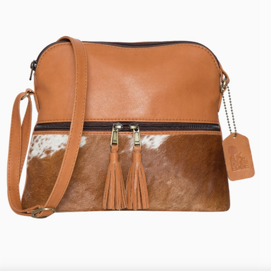 Brown leather crossbody bag with cowhide pattern and tassels on a white background