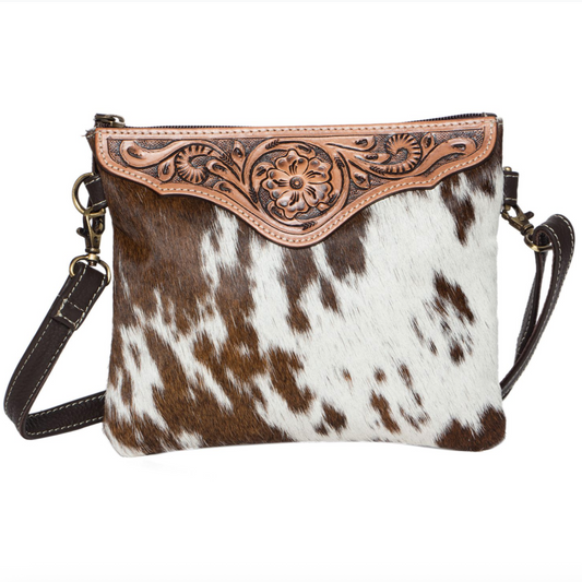 Cowhide leather crossbody bag with intricate brown leather flap on a white background