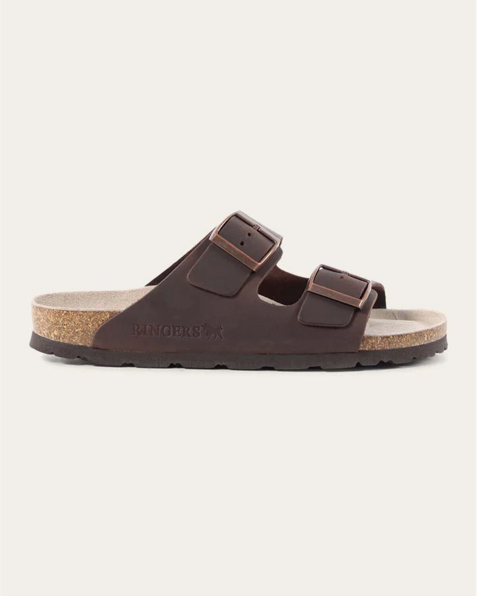 Brown sandal with branding on a light beige background
