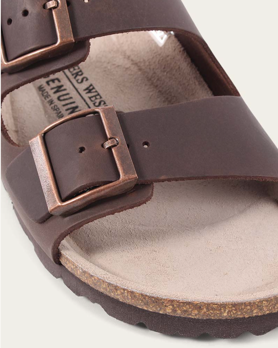 Brown sandal with a strap and cork sole on a white background