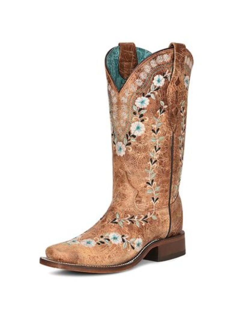 Tan cowboy boot with floral embroidery on a white background