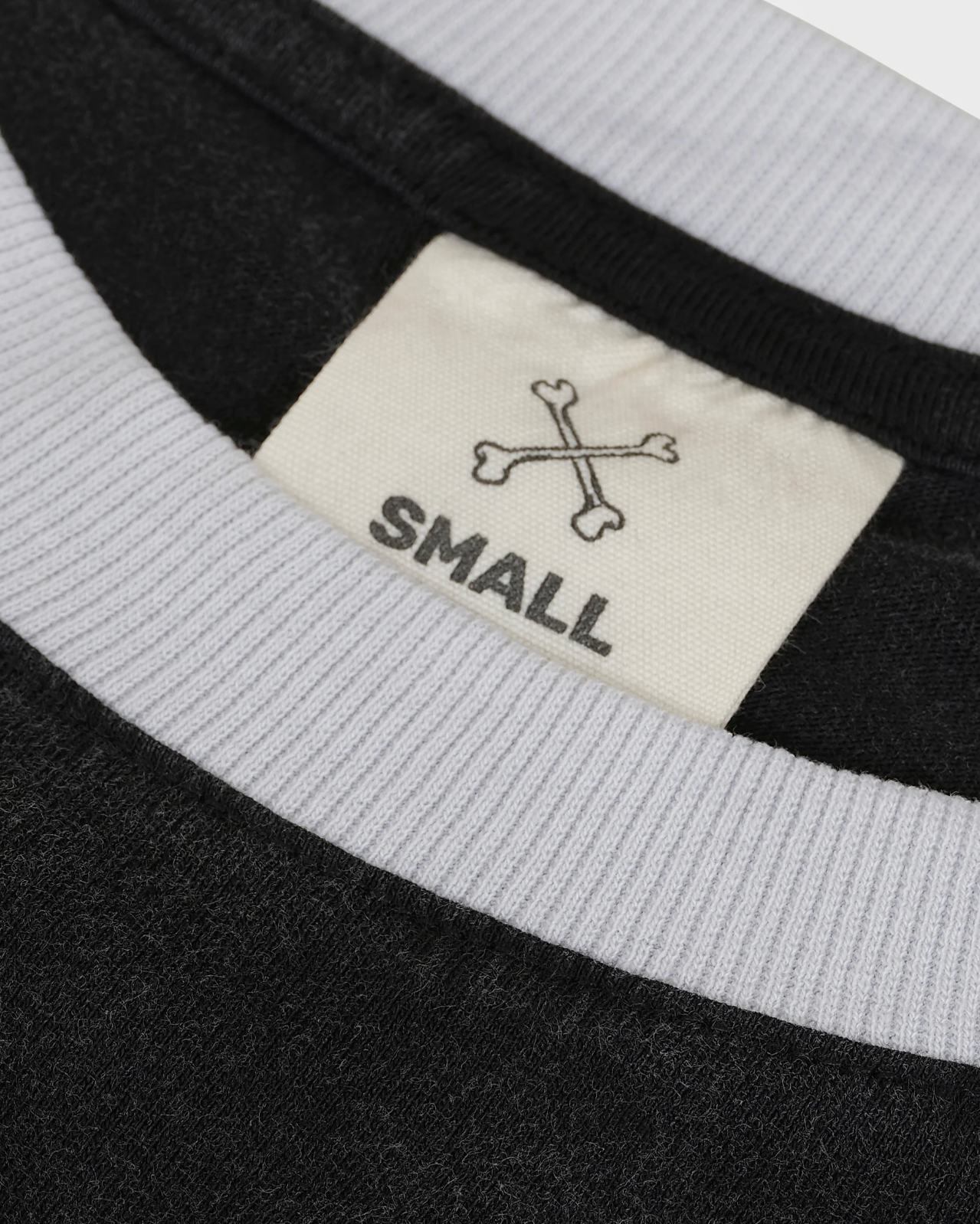 Close-up of a label on a garment with text 'SMALL' and a logo.