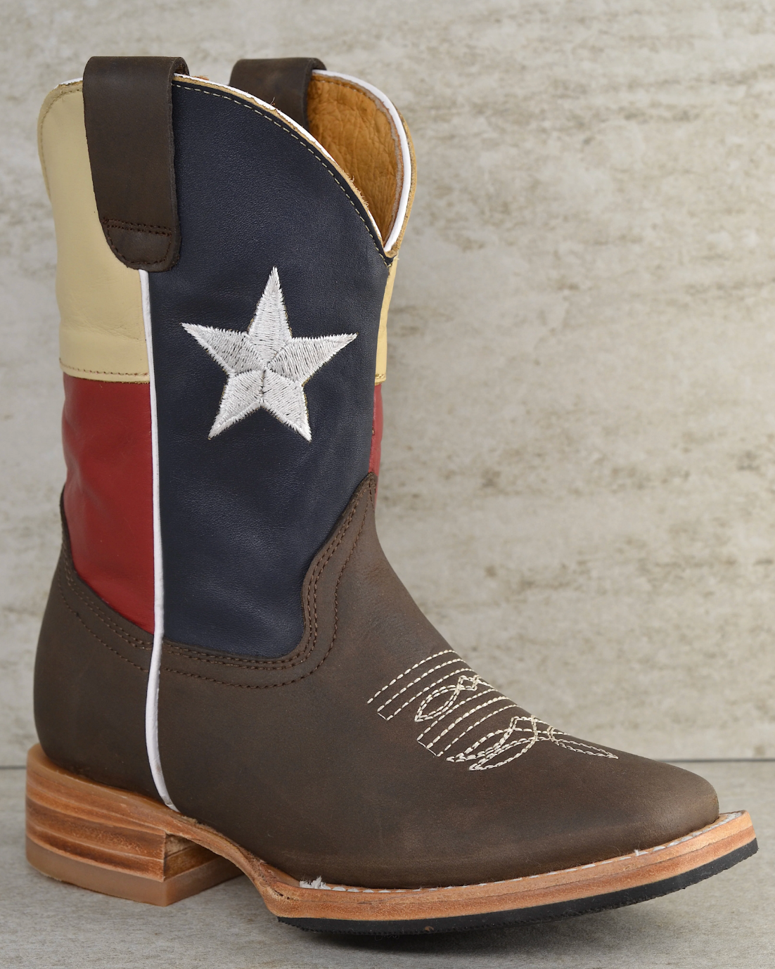 Cowboy boot with Texas flag design on a textured surface