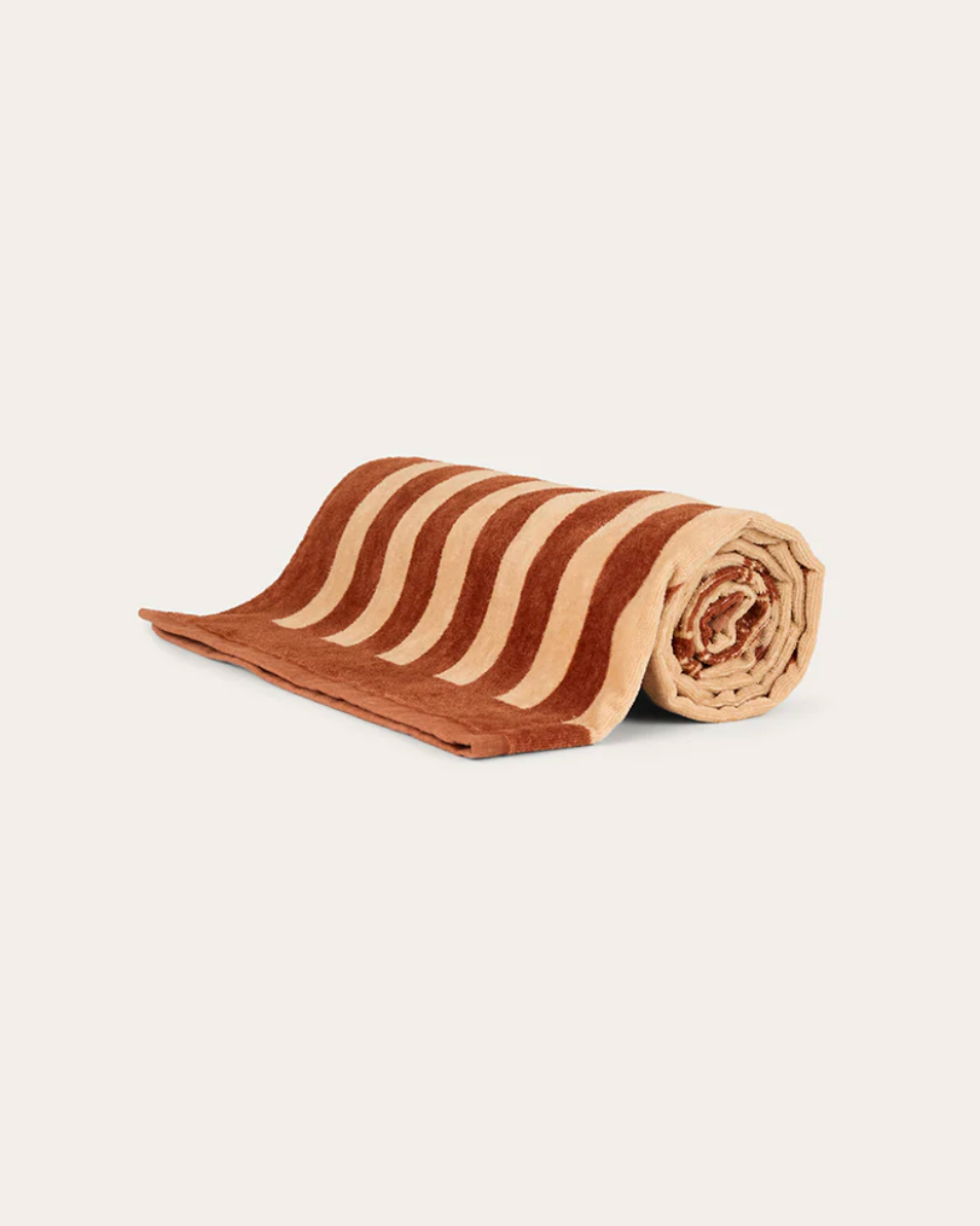 Rolled-up towel with brown and beige stripes on a white background