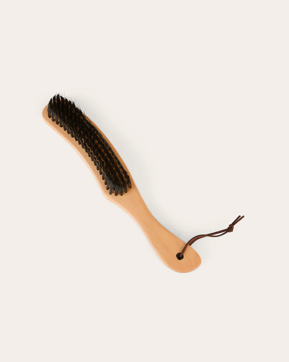 Wooden brush with black bristles on a white background