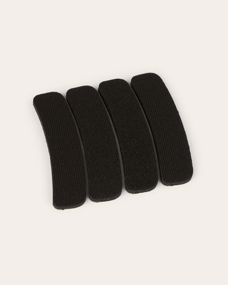 Five black hair clips arranged on a white background