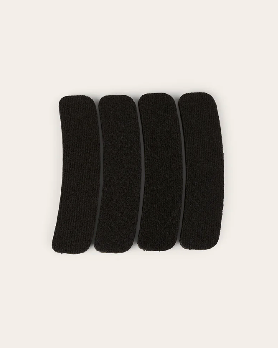 Five black hair elastics on a white background