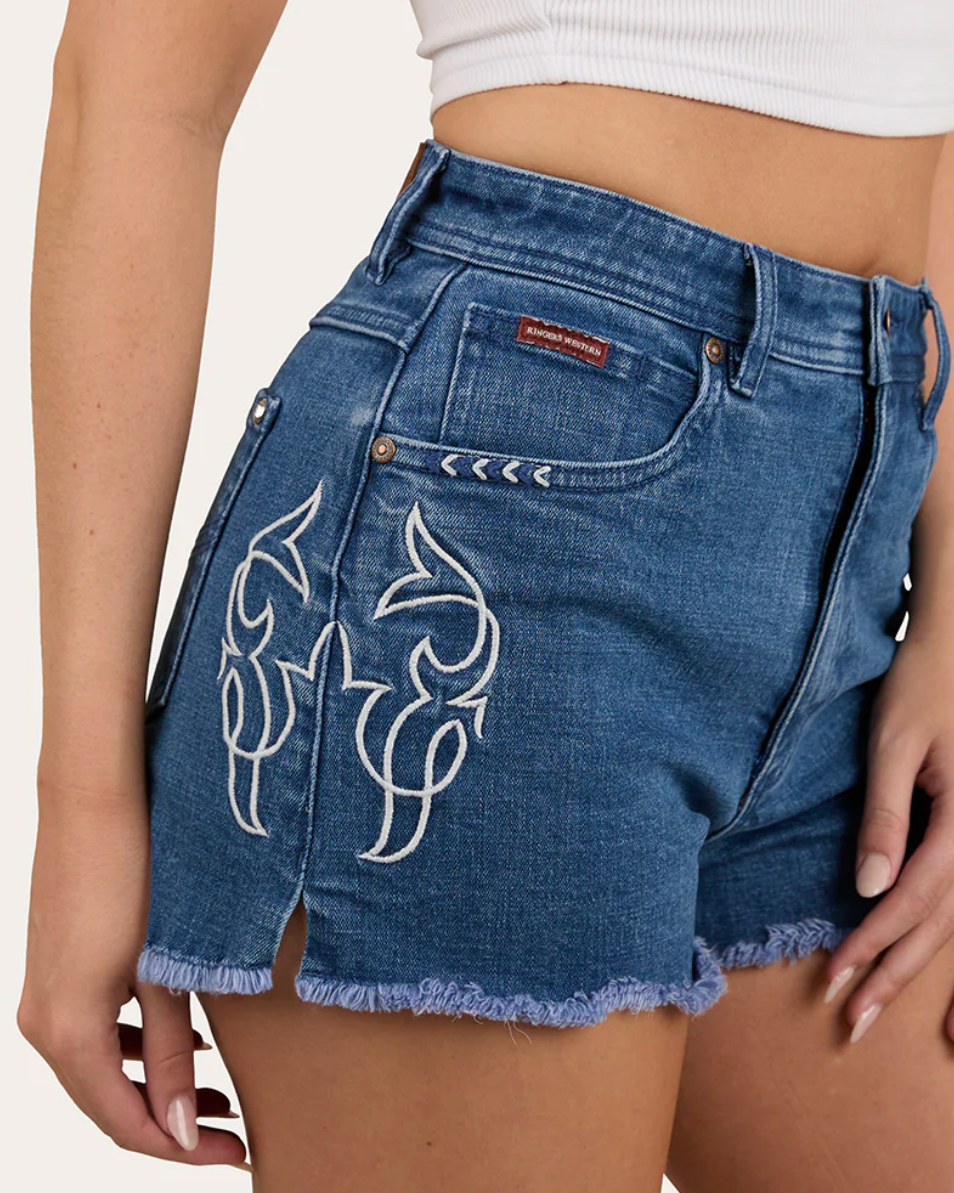 Blue denim shorts with white embroidery on a neutral background