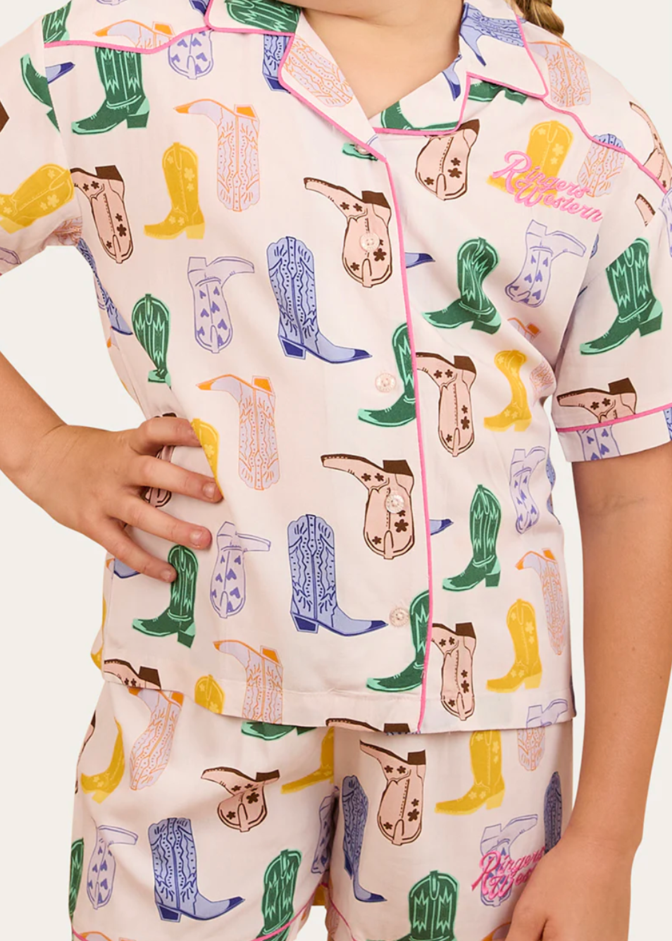 Child wearing pajamas with colorful cowboy boot pattern on a white background