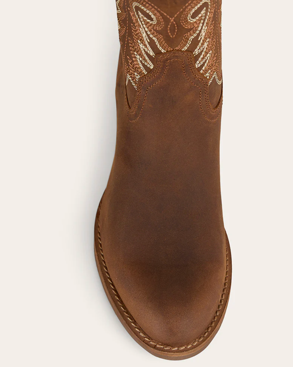 Brown cowboy boot with intricate white embroidery on a white background