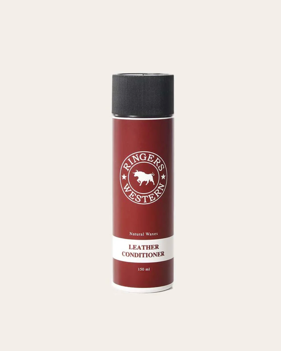 Red leather conditioner bottle with black cap on a white background