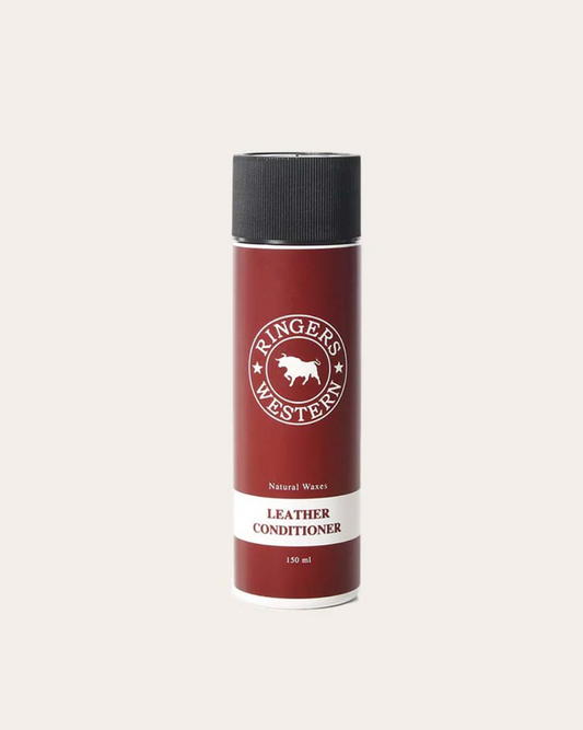 Red leather conditioner bottle with black cap on a white background