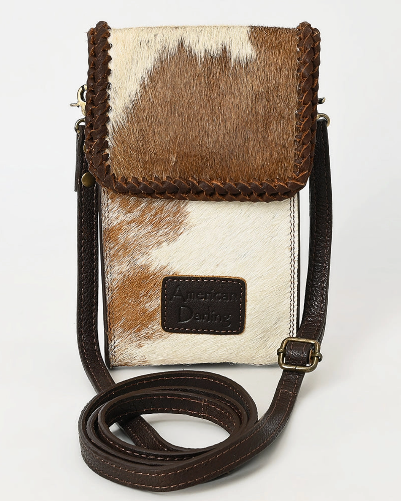 Phone case with cowhide pattern and brown strap on a white background