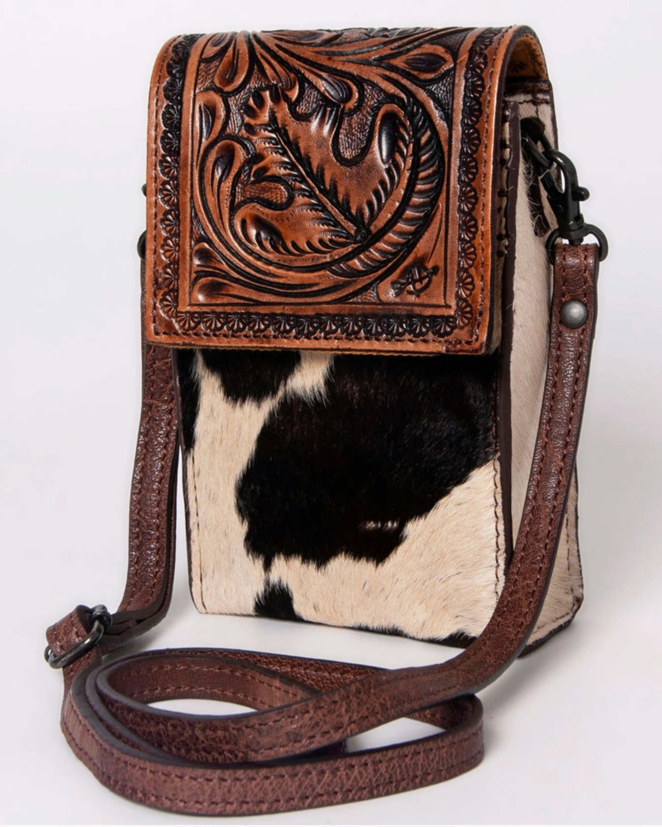 Handbag with cowhide pattern and intricate brown leather design on a white background