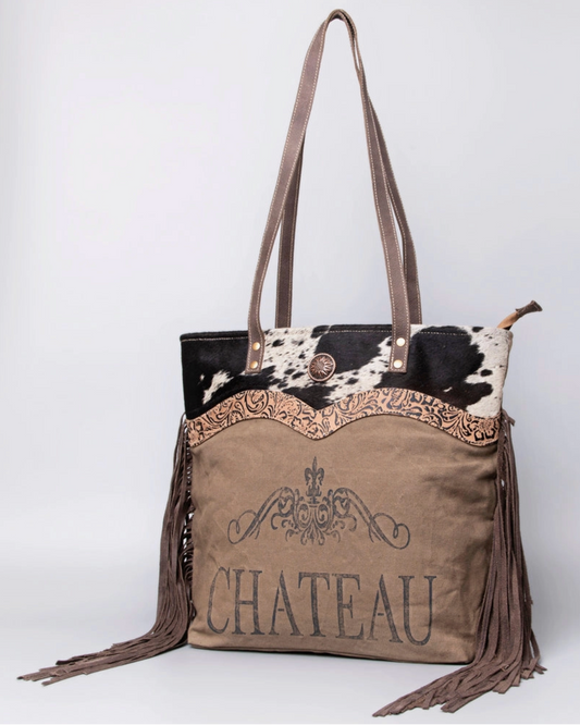 Brown handbag with cowhide accents and 'Chateau' branding on a white background