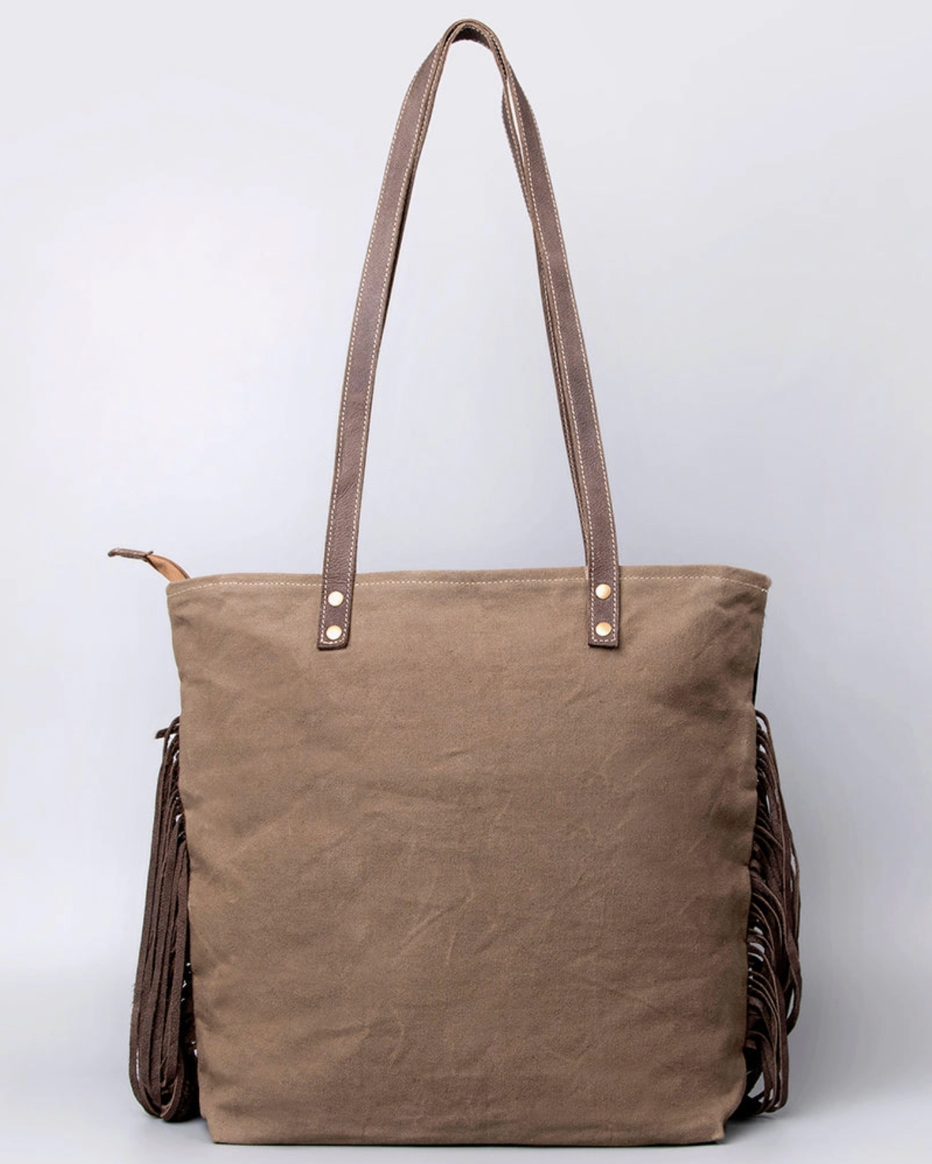 Brown tote bag with fringe details on a light gray background