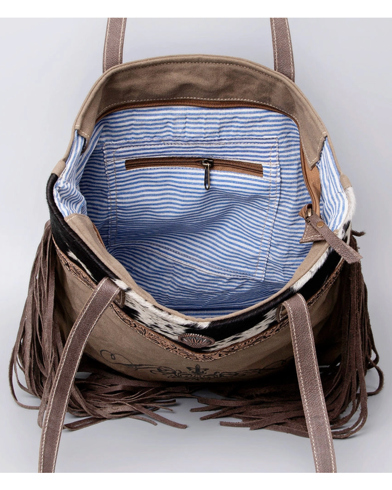 Brown leather backpack with fringe details on a white background