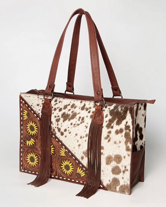 Handbag with cow print and decorative patterns on a white background