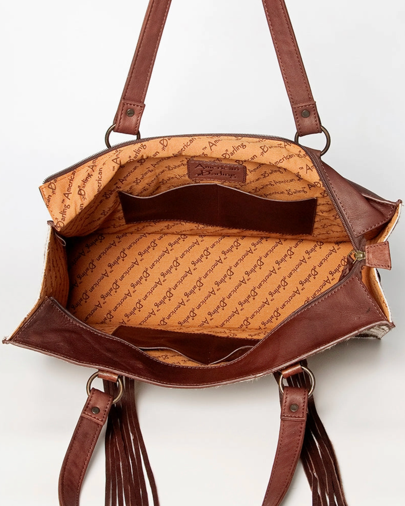 Brown leather handbag with visible brand name on a white background
