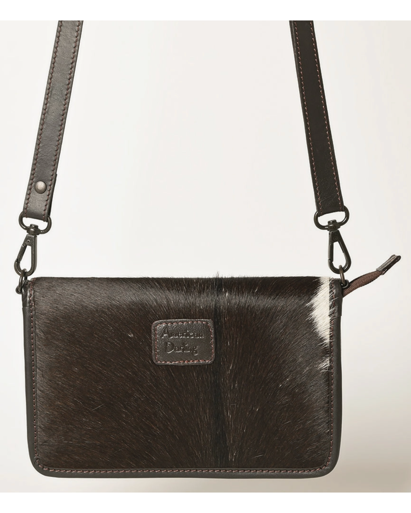 Black cowhide leather crossbody bag with a visible brand logo on a light gray background