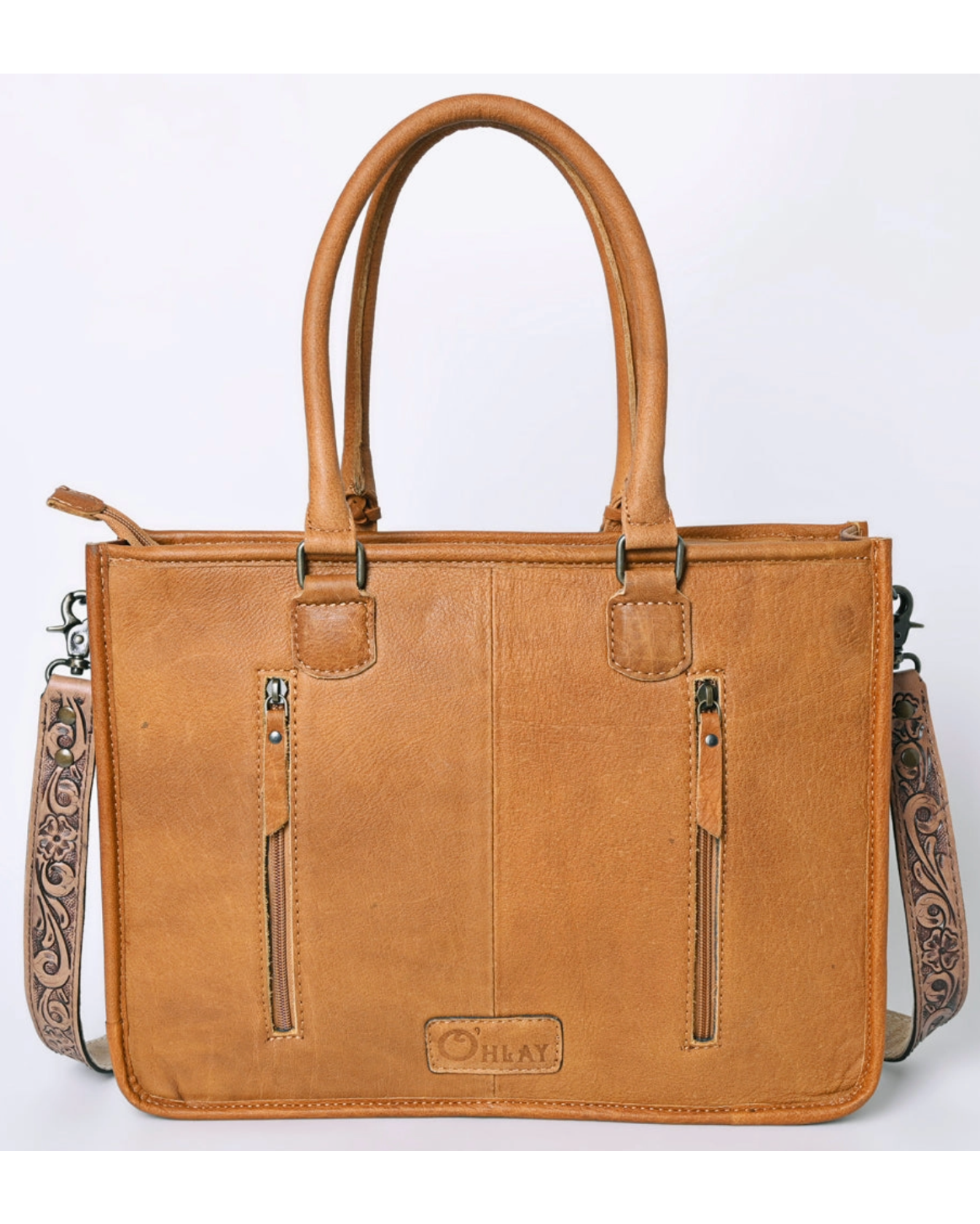 Brown leather handbag with decorative straps on a white background