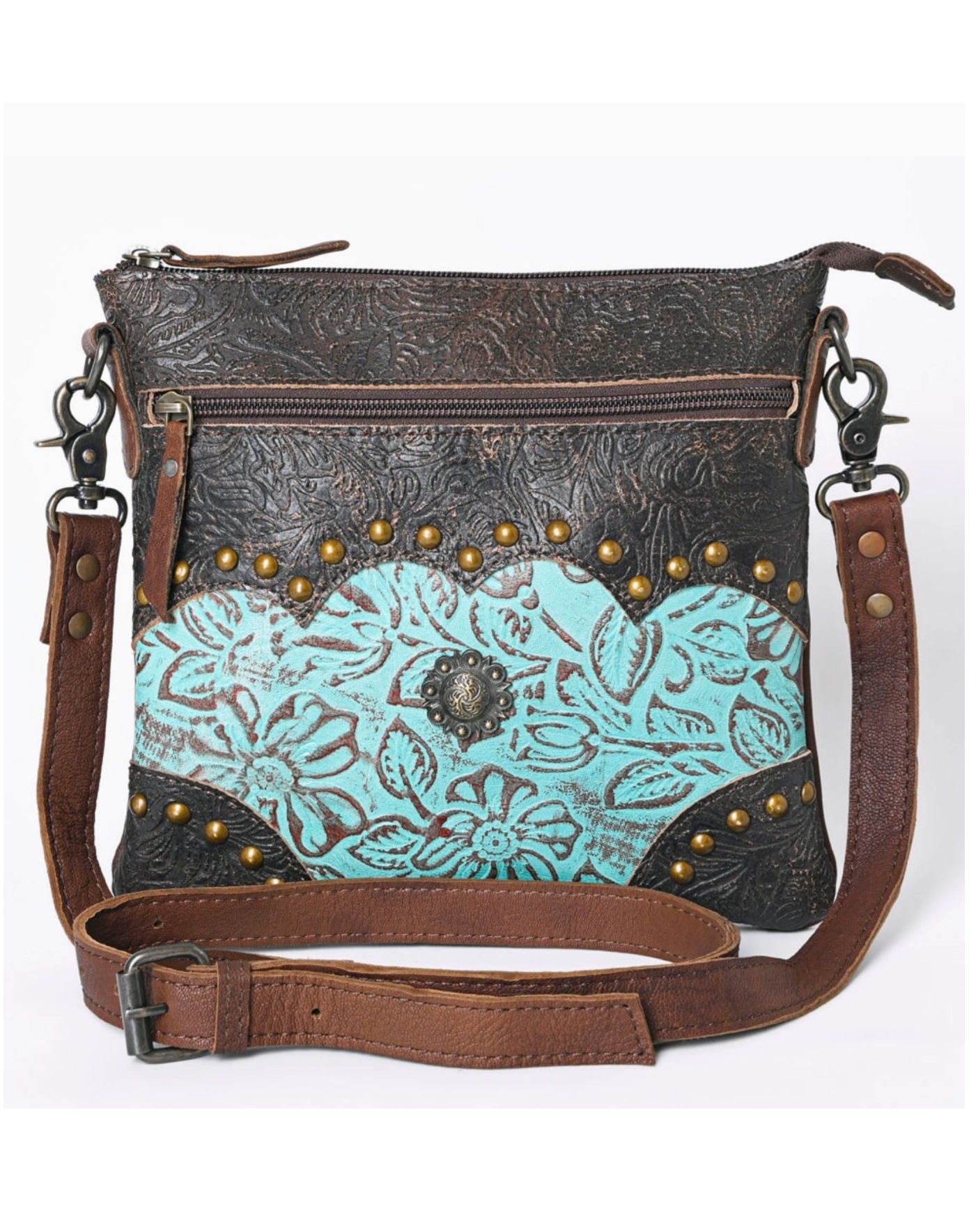 Brown and turquoise leather crossbody bag with floral patterns and studs on a white background