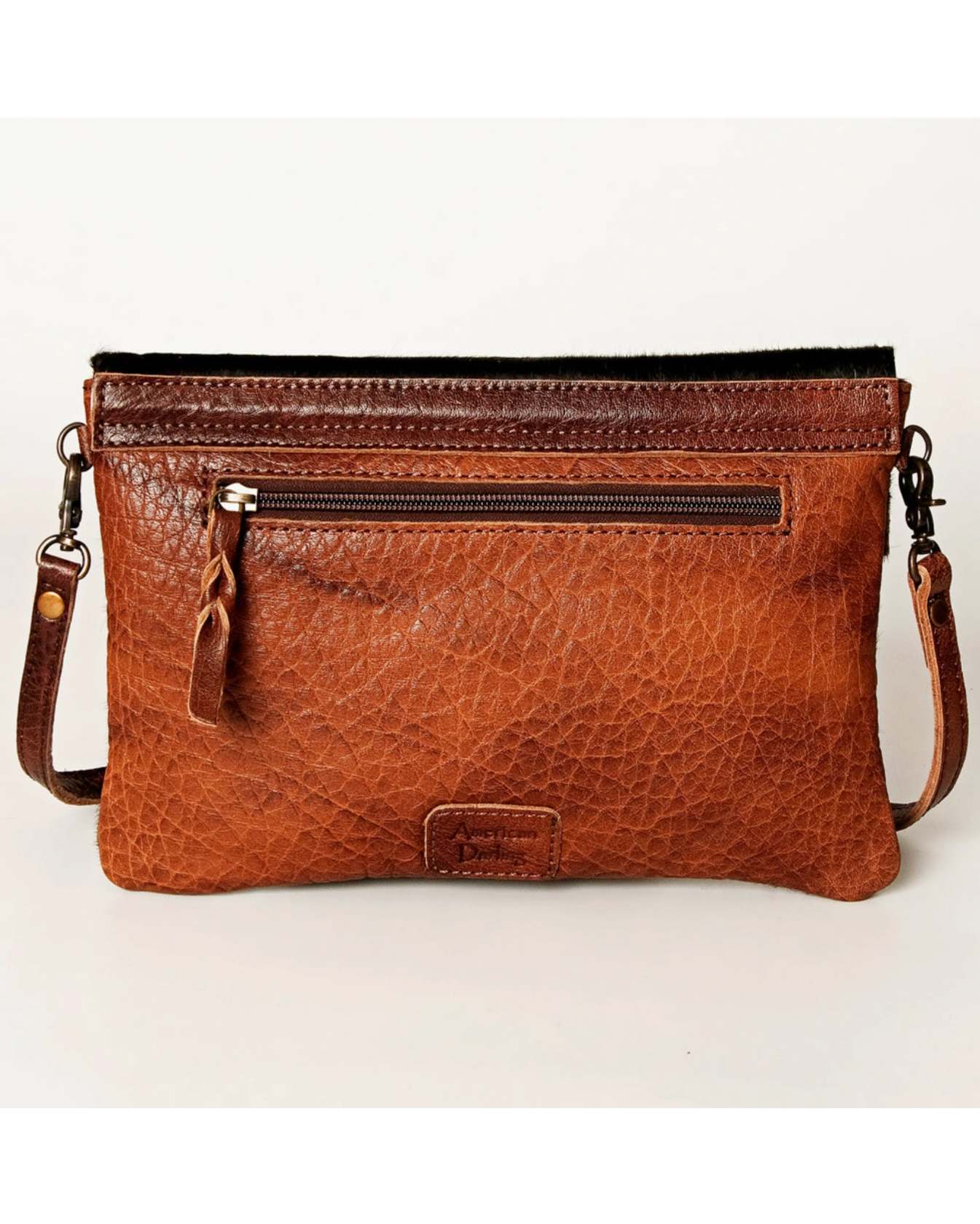 Brown leather handbag with a strap on a light background
