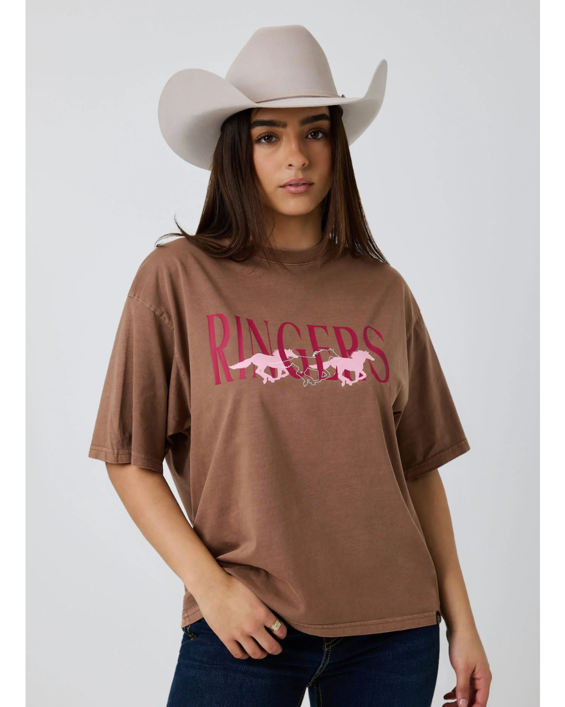 Ringers Western: Woman's 100% Cotton Brown Oversized Tee with a "Running Herd" Graphic on the front in pink - Texas Western New Zealand