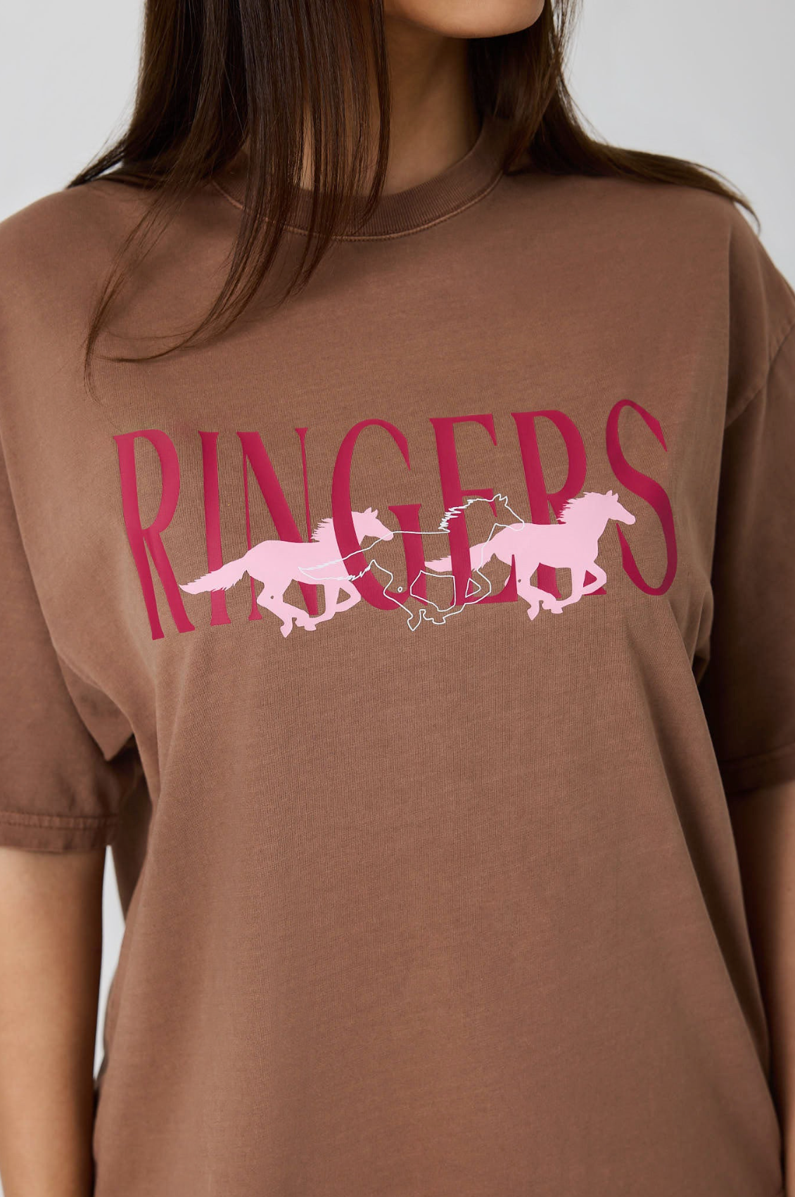 Ringers Western: Woman's 100% Cotton Brown Oversized Tee with a "Running Herd" Graphic on the front in pink - Texas Western New Zealand
