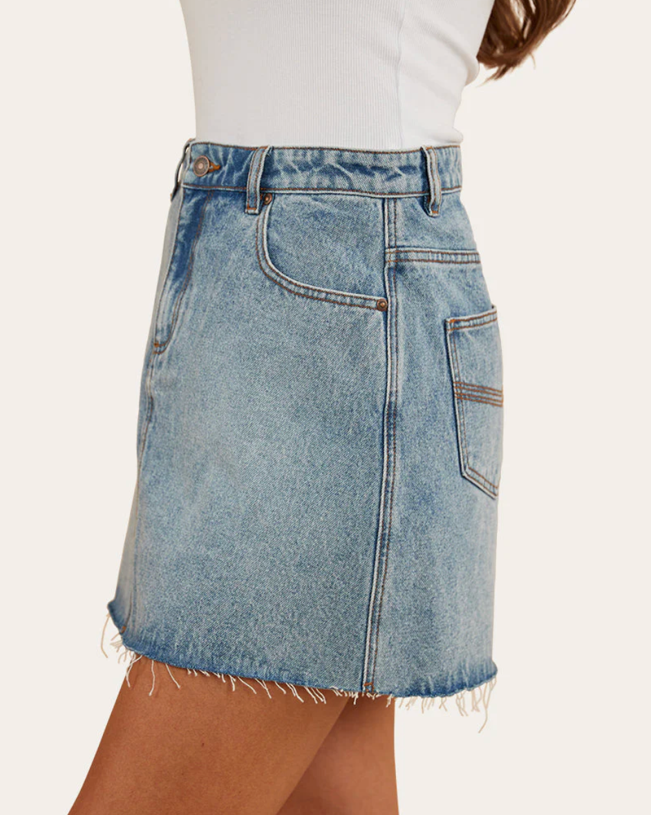 Denim skirt worn by a person on a white background
