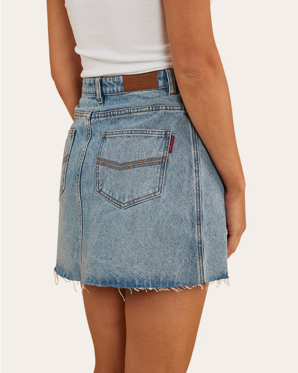 Denim skirt worn by a person on a white background