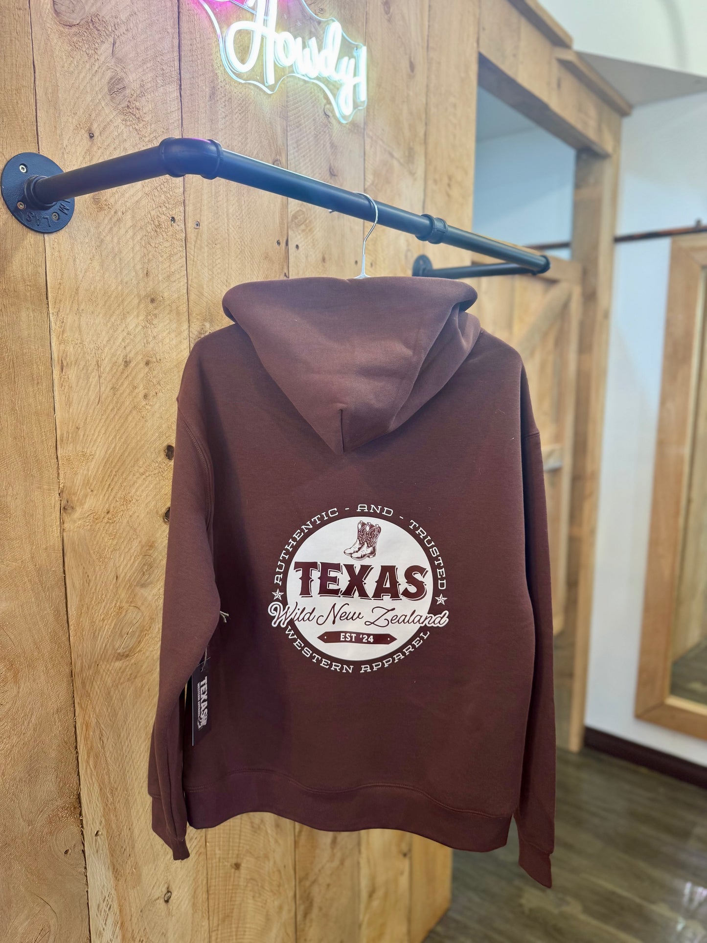 Chestnut Brown Texas Western Apparel hoodie with intricate embroidery. The front features a detailed embroidered 'T' and a Western-style boot, while the back showcases the Texas Western Apparel logo. A bold and stylish statement piece with a classic country flair.