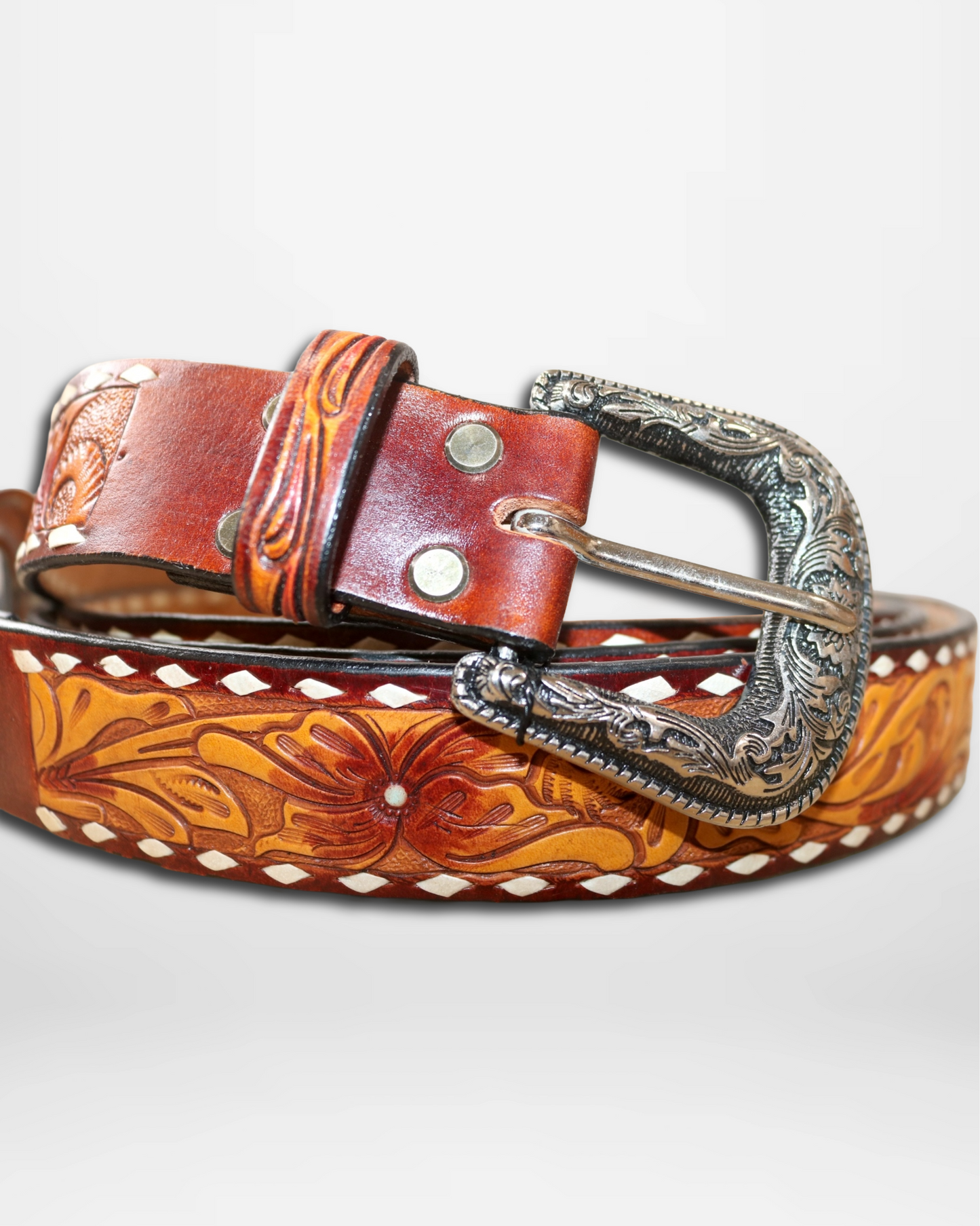 Brown leather belt with intricate designs and a silver buckle on a white background